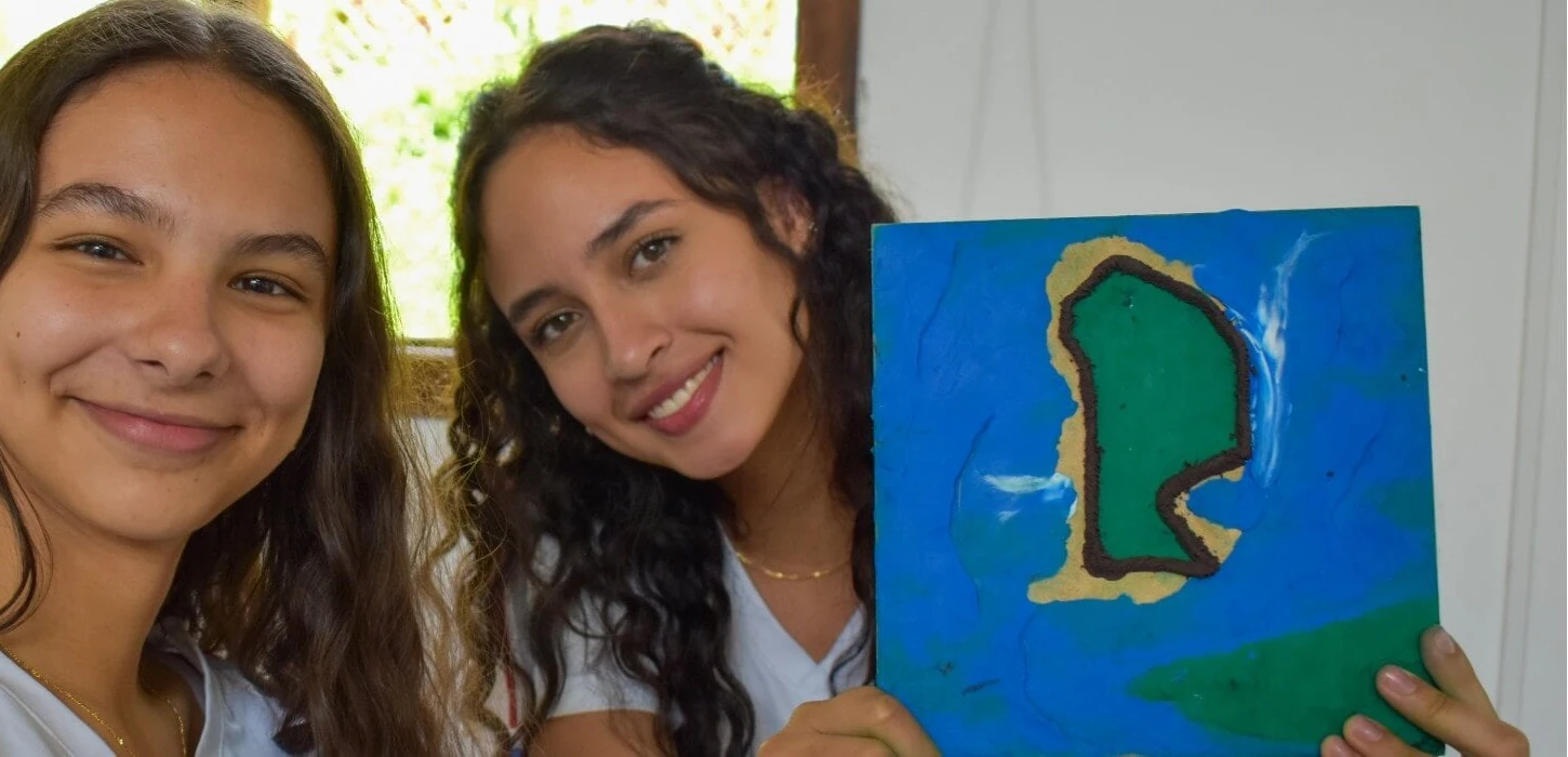 Dos estudiantes del Liceo Taller San Miguel sonríen a la cámara en el aula